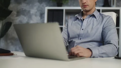 Young male office worker analyzing data and working on project using laptop Stock Footage 340960503