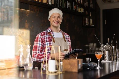 Young male owner using digital tablet while standing in cafe. Stock Photos