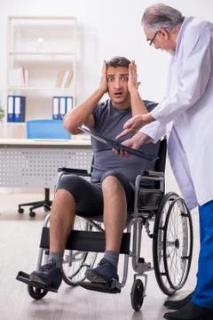 Young male patient in wheel-chair visiting old doctor radiologis Stock Photos