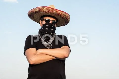 Young male person dressed up as gangster in traditional sombrero, bandana. Stock Photos