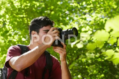 Young male photographer hiking in forest Stock Photos