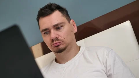 Young male professional using a computer while sitting in his home office. Busy Stock Footage 254591222