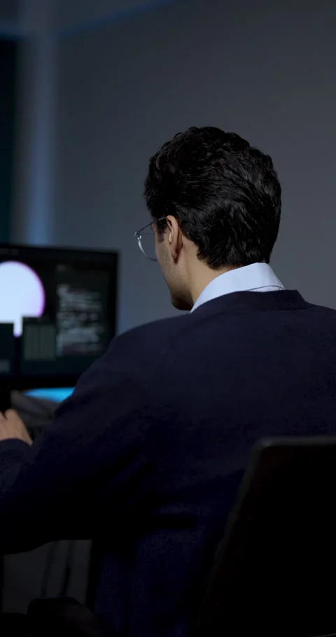 Young male professional works at computer workstation, reviewing software Vídeo Stock 343732607