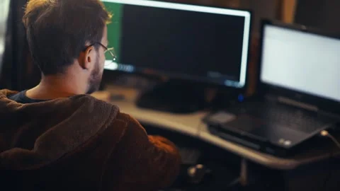 Young male programmer hacker works at a computer at home Stock Footage 138605284