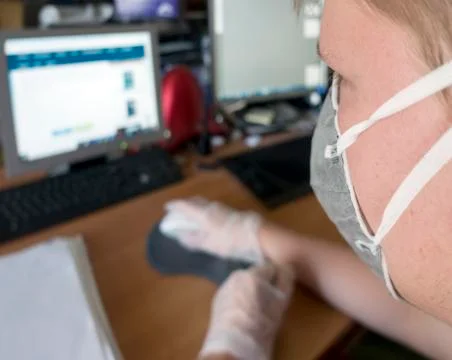 Young male programmer working at a computer in a protective mask and gloves Stock-Fotos