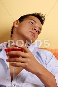 Young male with red cocktail Stock Photos