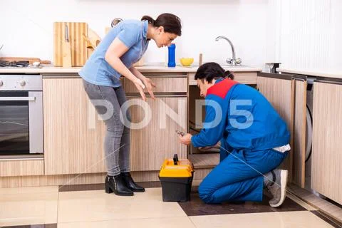 Young male repairman repairing tap Stock Photos