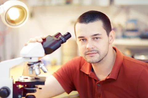 Young Male Researcher with Microscope Foto stock