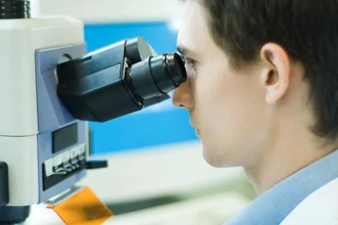 Young male scientist using microscope Stock Photos