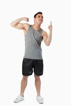 Young male showing his biceps while pointing up Stock Photos