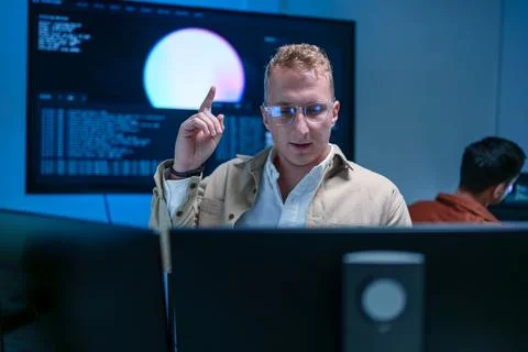 Young male software developer raising finger with an idea while working on .. Stock Photos