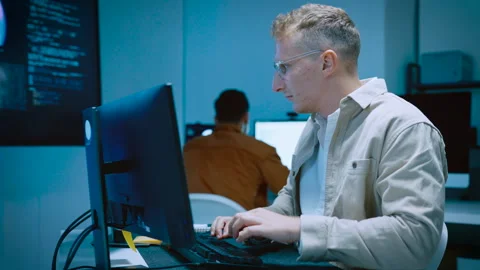 Young male software developer typing and reviewing code while designing web.. Video stock 337046512