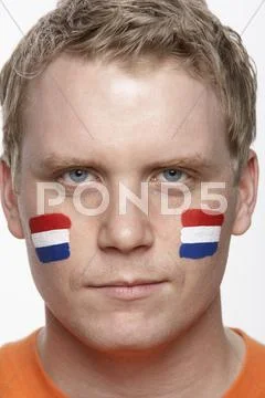 Young Male Sports Fan With Dutch Flag Painted On Face Stock-Fotos