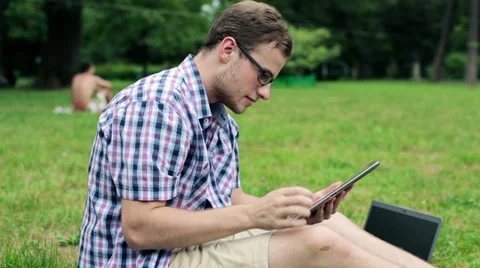 Young male student with tablet computer in the park HD Stock Footage 27716237