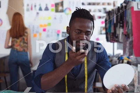 Young male student using smartphone at a fashion college Stock Photos