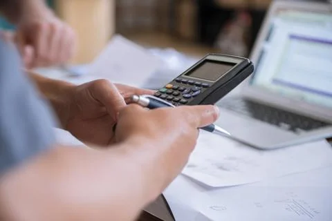 Young male using calculator to do math schoolwork in a home setting Foto stock