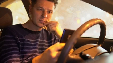 Young male using mobile phone in the car in the evening Video stock 101352792