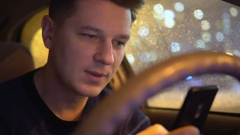 Young male using mobile phone in the car in the evening Stock Footage 101355260