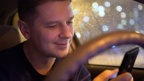 Young male using mobile phone in the car in the evening Video stock 101355869