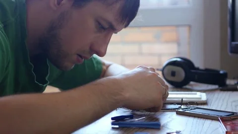 A young male wizard versed in the small details of broken phone, want to repair Stock Footage 73726868