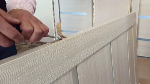 A young male worker assembles an interior door. Stock Footage 159485977