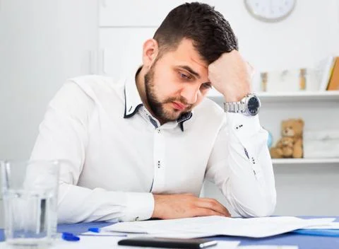 Young male worker having problem in project in office Foto stock