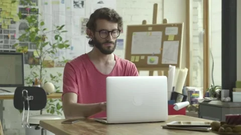 Young male working in front of computer at his cosy stylish house, flat, Stock Footage 245423154