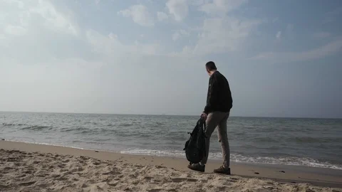 Young man 20 years old walks along the coast of the Baltic Sea with a backpack Stock Footage 109160189
