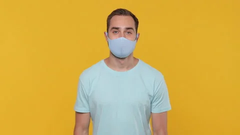 Young man 20s in basic casual blue t-shirt showing thumbs up pointing on sterile Video stock 148292185