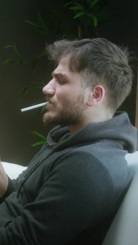 Young man about to smoke a cigarette but changes his mind and throws it awa.. Stock Footage 307544006