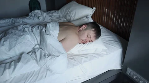 Young man is about to sneeze being ill. Attractive young man sleeping in his bed Stock Footage 171979632