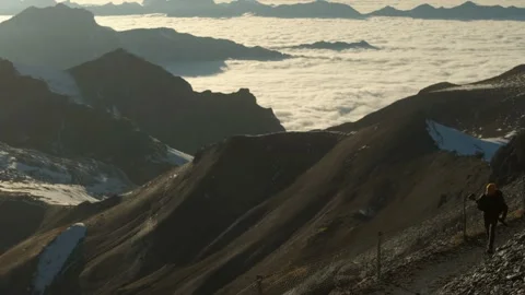 The young man above the clouds ascending mountain top on hiking trail Stock Footage 201165038