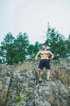 A young man with abs cubes on the background of the forest. Athletic pumped.. 写真素材