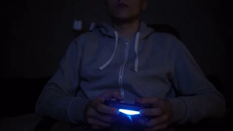 Young Man Absorbed In Online Video Game at night. Controller, console, gamepad Stockbeeldmateriaal 73751898