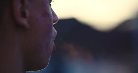 Young man with acne breathing hard after morning exercise backlit by sunrise  Stock Footage 308754369