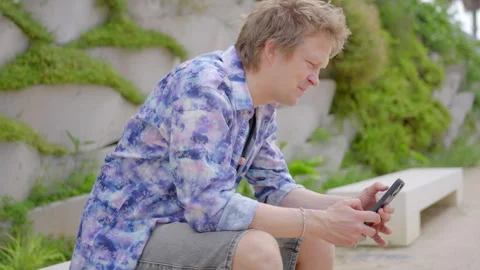 A young man is actively engaged with the latest mobile technology in a casual Stock Footage 281608808