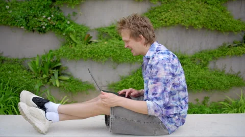 A Young Man Actively Engaged with Technology While Surrounded by the Beauty of Stock Footage 284305620