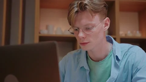 Young man actively typing and looking at the laptop, working from home Video stock 164374339