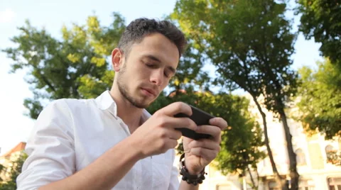 Young man actively typing a message on his smartphone Stock Footage 62313245