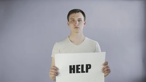 Young Man Activist With HELP Poster on grey background Stock Footage 111868956