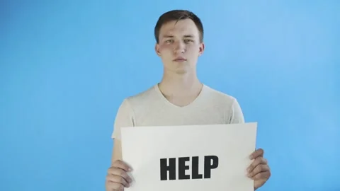 Young Man Activist With HELP Poster on blue background Stock Footage 130991515