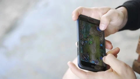 Young man addict playing mobile game ROV on smart phone Stock-Footage 125785951