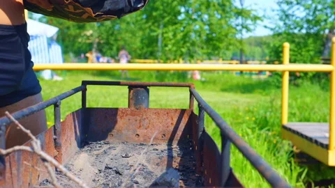 A young man adds coals into a brazier Video stock 133997378