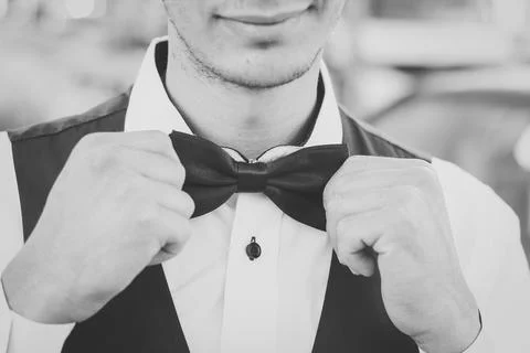 Young man adjusting black bow tie Foto stock