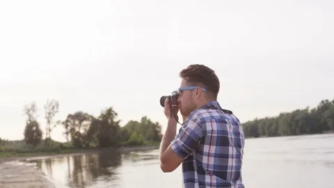 Young Man Adjusting the Camera in the Wild Stock Footage 76467854