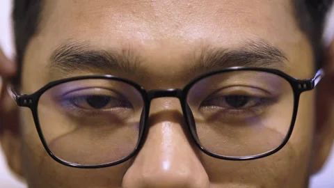 Young Man Adjusting Glasses and Staring Intently. Close-Up of Focused Man W.. Stock Footage 312370164