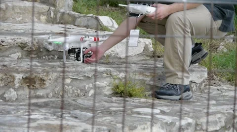 Young Man Adjusts Camera on Drone Stock Footage 65152080