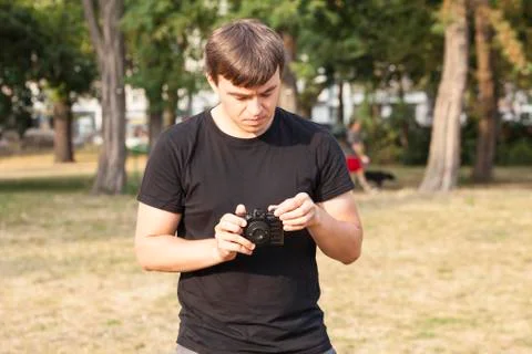 Young man adjusts camera Stock Photos