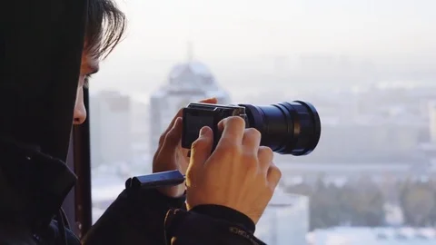 Young man adjusts the camera on the window background close-up Video stock 82879190