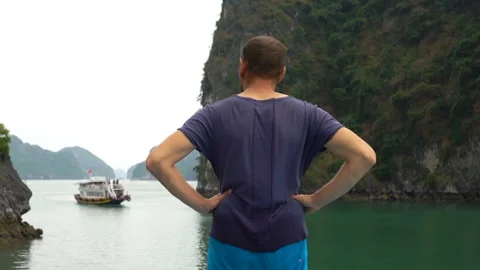 Young man admire beautiful view at Halong Bay in Vietnam Stock Footage 163330856